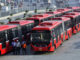 TO GO WITH Pakistan-unrest-vote-politics-development-education,FOCUS by Khurram Shahzad
In this photograph taken on June 5, 2013, shows Pakistani employees walking beside metro buses parked at a terminal in the provincial capital Lahore. Pakistanis are hoping their new prime minister will roll out high-profile projects that became his party's trademark in its political heartland of Punjab, but the nation's dire finances threaten the optimism. The Pakistan Muslim League-N (PML-N) won huge popularity and a reputation for getting things done with a series of big-ticket schemes over the past five years in Punjab, the country's richest, most populous province. A metro bus system in the provincial capital Lahore -- the first such scheme in the country's 65-year history -- free laptops and solar energy panels for students and a network of high-quality schools in poor rural areas made Punjab the envy of Pakistan. AFP PHOTO / ARIF ALI