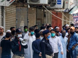 A police officer uses megaphone to disperse shopkeepers, who gather to reopen their shops at a closed electronics market, as the lockdown continues during the efforts to stop the spread of the coronavirus disease (COVID-19), in Karachi, Pakistan April 27, 2020. REUTERS/Akhtar Soomro